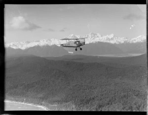 Air Travel New Zealand Ltd de Havilland DH 83 Fox Moth aeroplane, in flight with snow-covered mountains in background