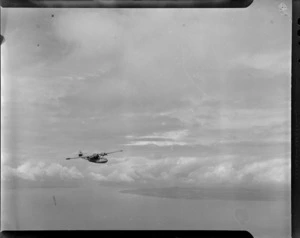 A Consolidated Catalina flying boat, [G Squadron?], flying over an unidentified location [Espirita Santos?]