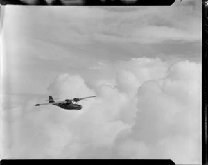 A Consolidated Catalina flying boat [G Squadron?], in flight over clouds, [Espirita Santos?]