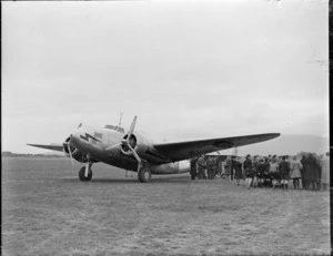 Lockheed Lodestar aeroplane, parked at unidentified location, with crowd [including Royal New Zealnd Air Force personnel?] alongside