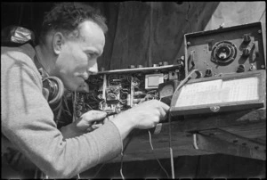 H L Willacy makes final adjustments to a wireless set on the Monte Cassino Front in Italy, World War II - Photograph taken by George Kaye