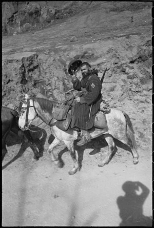 Mounted French Moroccan trooper raises steel helmet in greeting to New Zealanders on the Cassino Front in Italy, World War II - Photograph taken by George Kaye