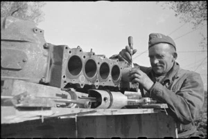 W J Miller fits a new piston to a motor at NZ Divisional Field Workshops, Italian Front, World War II - Photograph taken by George Kaye