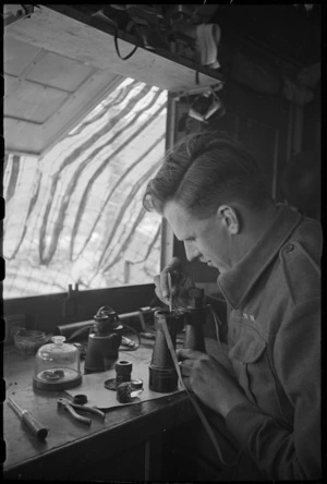 M Lang repairing binoculars at NZ Divisional Field Workshops, Italian Front, World War II - Photograph taken by George Kaye