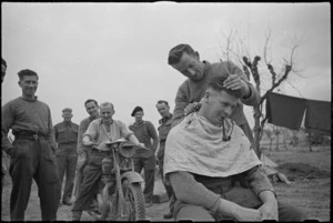 NZ Infantry soldier has a haircut behind the lines on the Cassino Front, Italy, World War II - Photograph taken by George Kaye