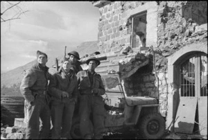Maori and pakeha soldiers beside damaged building on 5th Army Front, Italy, World War II - Photograph taken by George Kaye