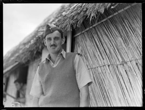 Portrait of Flying Officer T G Moore in front of a thatched hut, [Fua'Amotu?] Airfield, Tonga