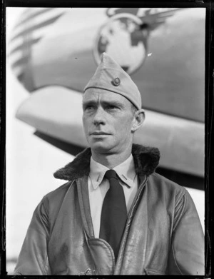 Portrait of Captain R Maxwell in front of a Pan American Airways plane, location unknown