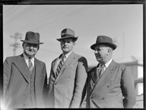 Portrait of (L to R) E Hewett, D G Sisson and A Playle of the Oceanic Steamship Company in front of cars, location unknown