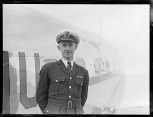 Portrait of Captain Len MacKenzie of Union Airways in front of a plane, Rongotai Airport, Wellington