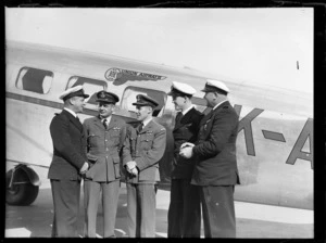 Portrait of Captains (L to R) M MacLeod (UA), M D Cullinane (RNZAF), B New (RNZAF), E Tate (UA) and A T Orchard (UA) in uniform in front of a Union Airways plane, Rongotai Airport, Wellington