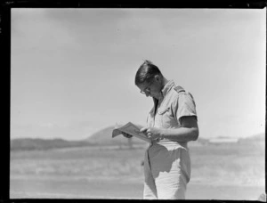 Portrait of Second Lieutenant C W Franks reading a magazine, Tontouta Airfield, New Caledonia