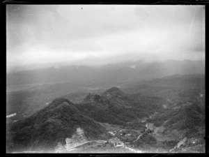 A rock quarry with processing plant and building, with forested mountains, Fiji