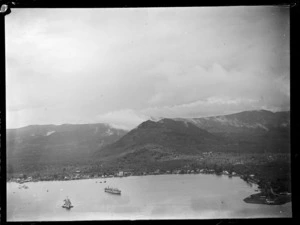 Apia Harbour with freight ships and coastal settlement, with forest covered mountains beyond, Western Samoa