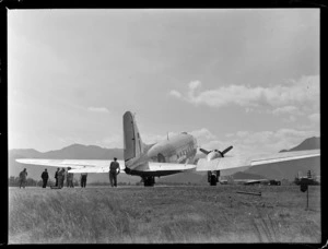 Tontouta Airfield and a rear view of a Dakota transport plane with unidentified personnel, New Caledonia