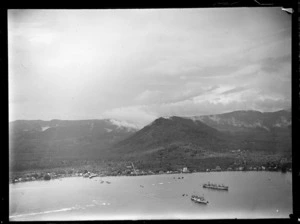 Apia Harbour with freight ships and coastal settlement, with forest covered mountains beyond, Western Samoa