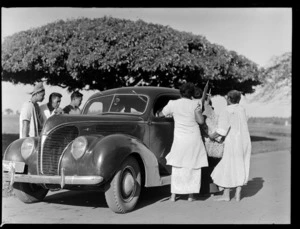 Souvenir sellers bartering with a car driver, Apia, Western Samoa