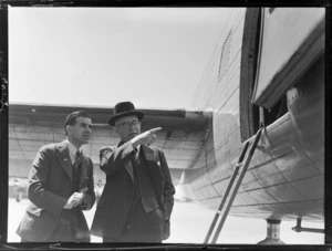 J C Allum, Mayor of Auckland and R M McIntosh, Permanent Head of Department of Internal Affairs looking at Lancastrian aircraft which returned the Prime Minister to NZ.