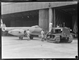 Gloster Meteor aeroplane EE395, towed by a tractor into hangar, RNZAF Station, Hobsonville, Auckland