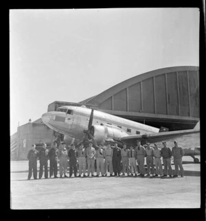 Royal New Zealand Air Force survey party for Japan, showing a group of men in front of C47 aeroplane , Whenuapai aerodrome, Auckland
