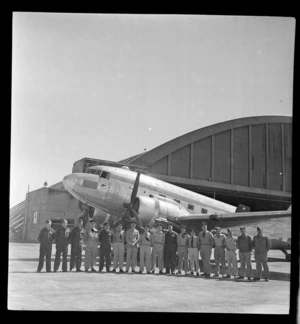 Royal New Zealand Air Force survey party for Japan, showing a group of men standing in front of a C47 aeroplane, Whenuapai aerodrome, Auckland