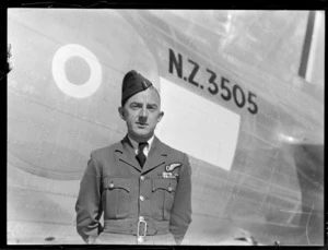 Portrait of RNZAF Flight Lieutenant JR McClemont, Navigator, for survey flight to Japan, at Whenuapai aerodrome, in front of aeroplane NZ3505