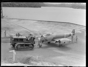 A disassembled Gloster Meteor aeroplane, being towed by a tractor at Hobsonville Air Base, Auckland
