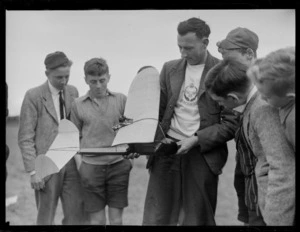 Reg Truman and a group of unidentified boys, looking at a 'Yogi' model aeroplane