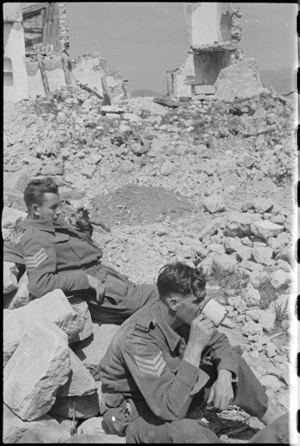 NZ Infantry sergeants W J Aldersley and E D Bougen rest among village ruins on Cassino battlefront, Italy, World War II - Photograph taken by George Kaye