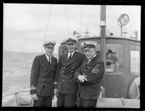 Portrait of Captain Burgess (centre) and two unidentified Auckland Harbour Board Pilots aboard an AHB pilot boat, Auckland Harbour
