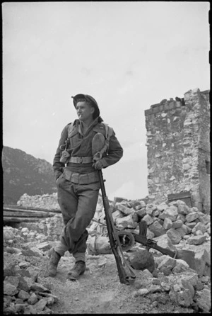 New Zealander J D Ruscoe leaning on his rifle on the Cassino battlefront, Italy - Photograph taken by George Kaye