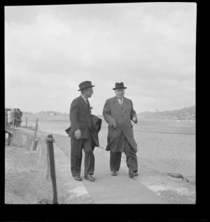 Portrait of Lord Winster, Great Britain's Minister for Civil Aviation, with Walter Nash walking off an Evans Bay wharf, Wellington City