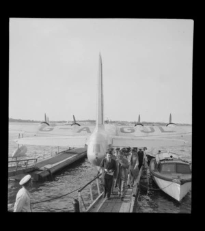 BOAC Hobart G-AGJL Short Hythe flying boat at Evans Bay wharves with Lord Winster, Great Britain's Minister for Civil Aviation, and unidentified people disembarking, Wellington Harbour