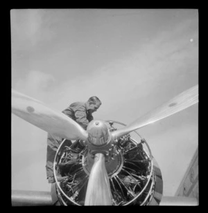 Close up view of an unidentified man working on a Pan American Airways Clipper Class Douglas Skymaster DC4 engine, on completion of 3rd survey flight, Whenuapai Airfield, Auckland