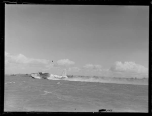 View of the BOAC Hobart G-AGJL Short Hythe flying boat with a British flag taking off from Auckland Harbour, Mechanic's Bay, Auckland