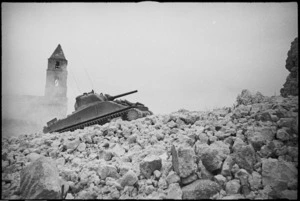 NZ Sherman tank climbs over ruined buildings on the Cassino Front, Italy, World War II - Photograph taken by George Kaye