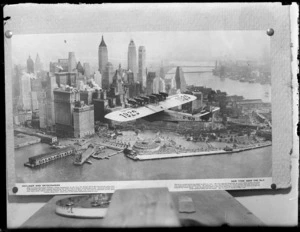 A copy photo of an aerial view of New York City and Harbour with a Dornier Do-X D-1929 German flying boat with 12 engines flying overhead