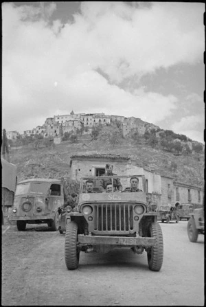 New Zealanders drive away from typical village on the Italian Front, World War II - Photograph taken by George Kaye