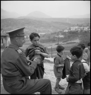 Major H T Knights examines Italian children for symptoms of malaria, Italy, World War II - Photograph taken by M D Elias