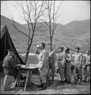 Major H T Knights supervises taking of Mepacrine antimalarial tablets by NZ troops as Staff Sergeant G R Oliver swallows his, Italy, World War II - Photograph taken by M D Elias