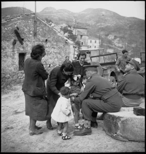 Italian mothers look on as Major H T Knights examines local children for enlarged spleens, Italy, World War II - Photograph taken by M D Elias