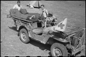 Unloading patients from a stretcher jeep by 6 NZ Field Ambulance personnel in Italy, World War II - Photograph taken by George Bull
