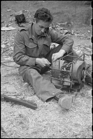 NZ Divisional Signals mechanic, J H Quittenden, makes repairs to chore horse at the Hove Dump, Cassino area, Italy - Photograph taken by George Bull