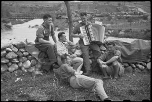Members of 6 NZ Infantry Brigade Band entertained with accordian music in Italy, World War II - Photograph taken by George Bull