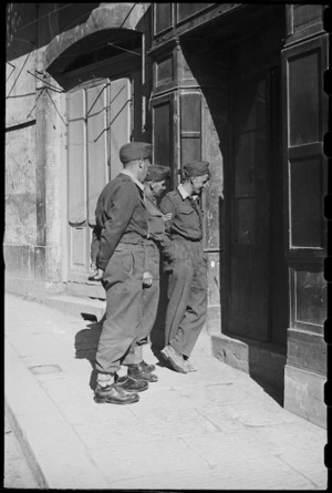 New Zealanders on leave watch local tradesman at work through shop window in Campobasso, Italy, during World War II - Photograph taken by George Bull