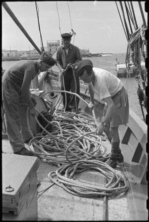 T O Lynds and R G Cliff, 1 NZ Convalescent Depot, help skipper coil cutter's rope, Santo Spirito, Italy, World War II - Photograph taken by George Bull