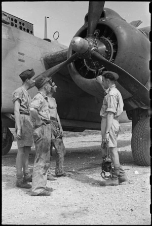 Air force personnel talking over performance of a night bomber on an aerodrome at Caserta, Italy, World War II - Photograph taken by George Bull
