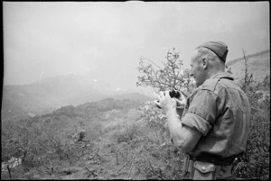 Lieutenant J R Johnson surveys enemy territory near forward machine gun posts, 8th Army Front, Italy World War II - Photograph taken by George Kaye