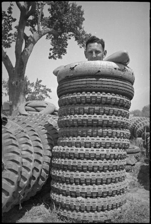 E H Tweedy with tyres for 2 NZ Division vehicles in forward areas of the Cassino Front, Italy, World War II - Photograph taken by George Kaye