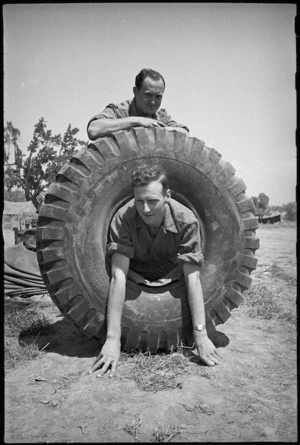 J McLennan and R Gibbs with large sized tyre for 2 NZ Division vehicle, Cassino Front, Italy, World War II - Photograph taken by George Kaye